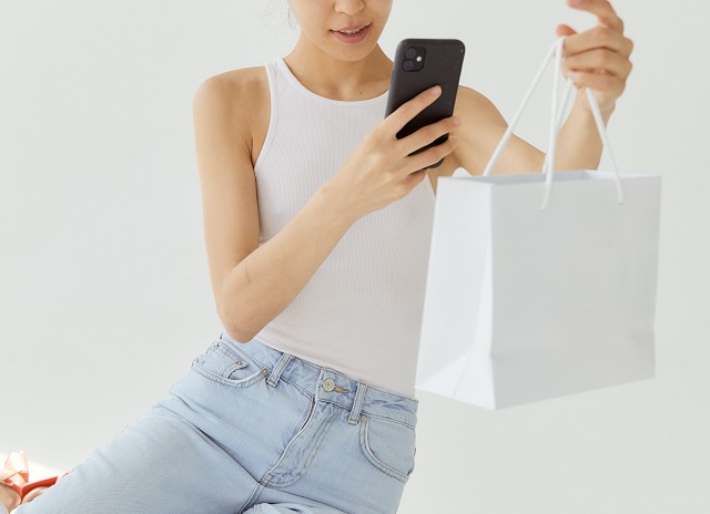 Woman taking picture of shopping bag