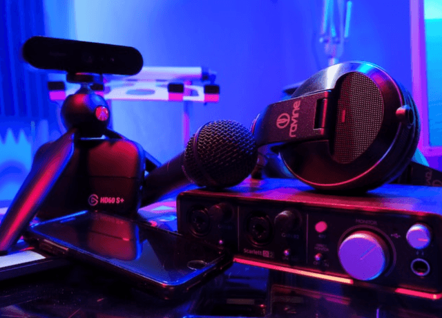 Pile of audio equipment in a room lit by blue LED lights