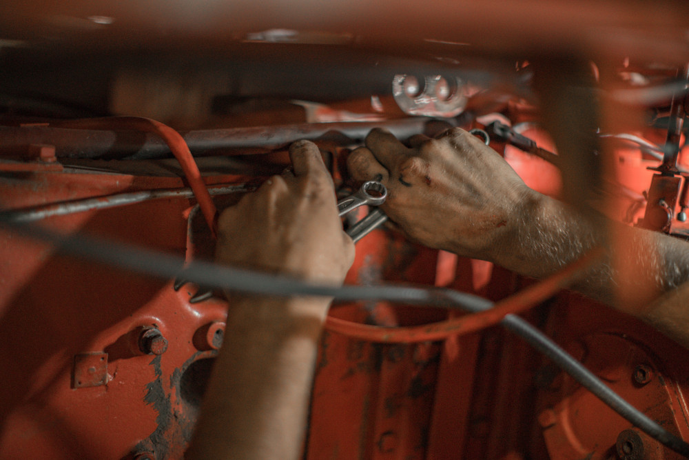 a mechanic operating on an engine in a physical business location