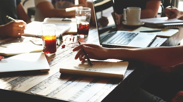 website builder hire pro people working together on a table with drinks