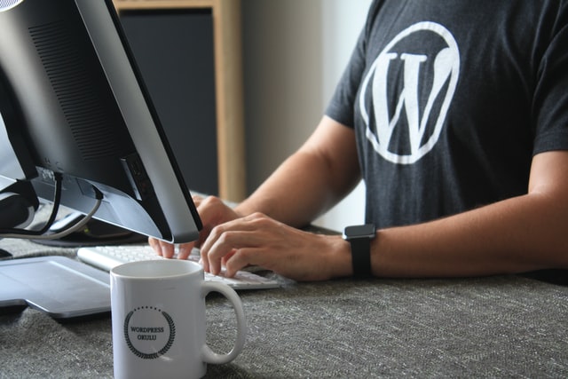 Developer at a desk wearing a WordPress t-shirt