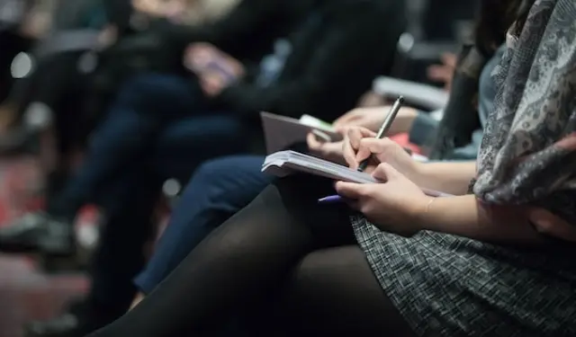 an image of people taking notes.