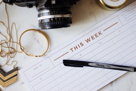 a picture of a weekly calendar placed next to a professional camera