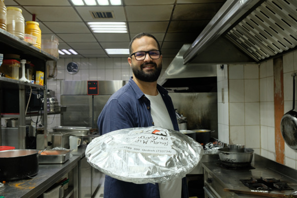 Maen Abbasi of Qedrah w Mansaf presenting Mansaf to the camera