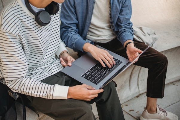 Two Guys Holding A Laptop