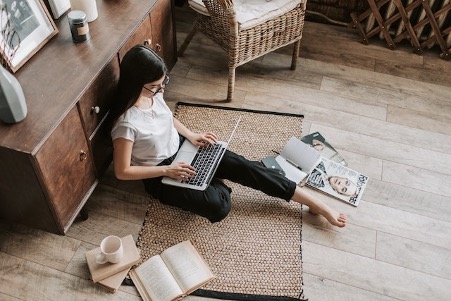 Woman Sitting On Floor Surrounded By Books And Magazines