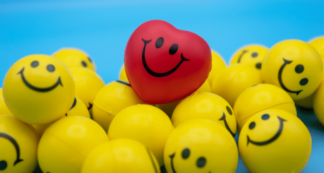 Heart-Shaped Stress Ball in Pile of Smiley-Faced Stress Balls