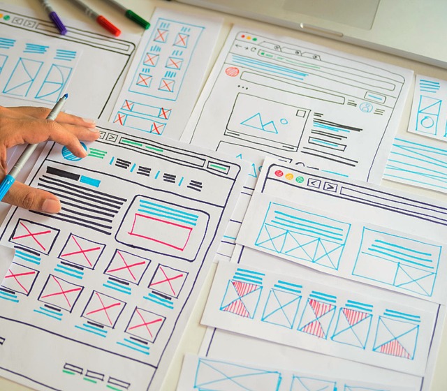 one hand writing drawing plan for website design on UX frames