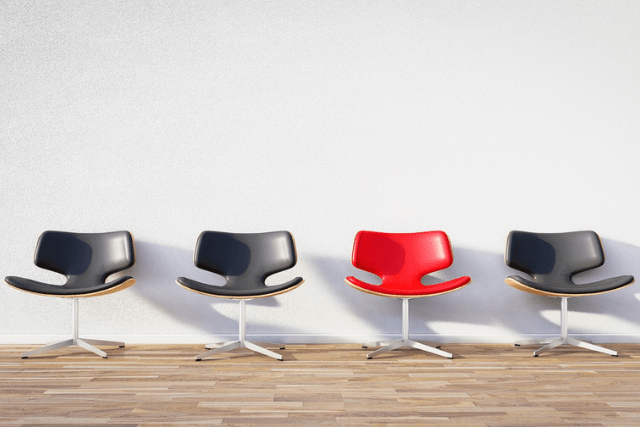 Red Office Chair in Row of Black Office Chairs