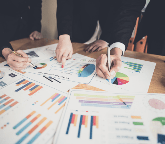 Three People Looking at Charts