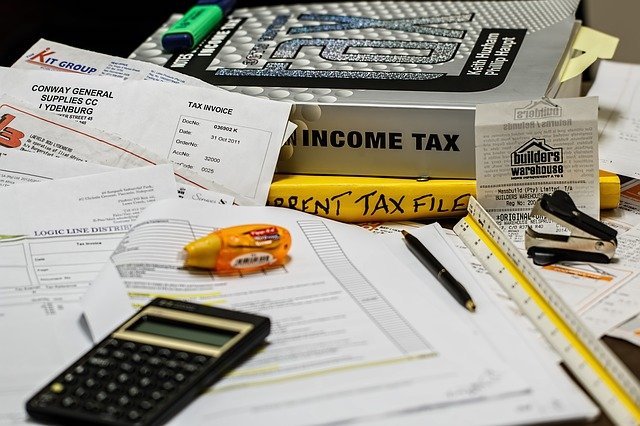 Calculator sitting on top of tax files and receipts