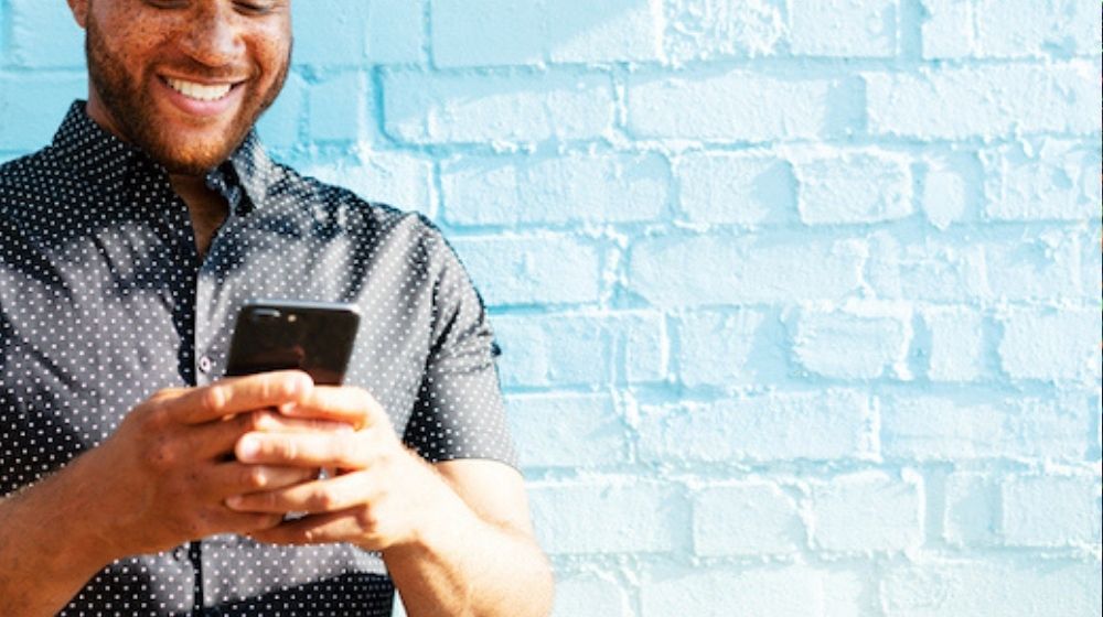 Man looking at his smartphone and smiling