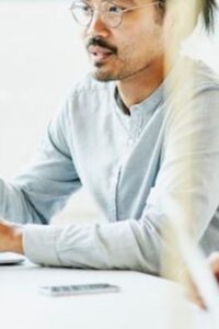 Man Sitting at Table Talking with Employees