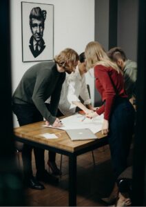 Management Consulting Team Bending Over Table