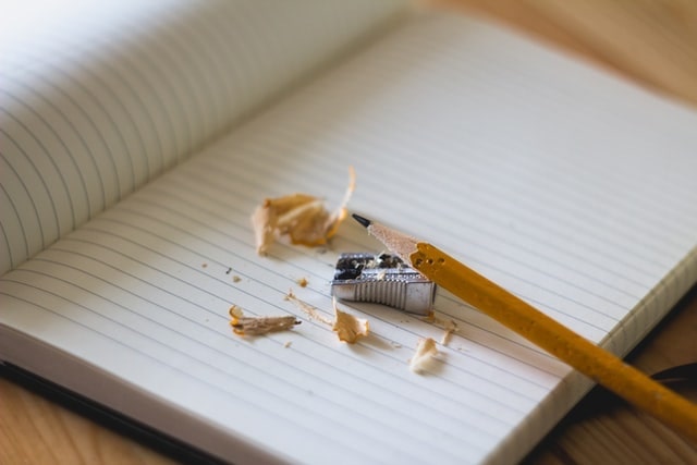 Pencil with pencil shavings on blank notebook