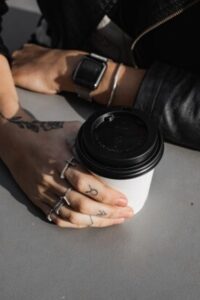 Person Holding Black and White Disposable Cup