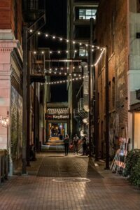 Person Walking Down Alley Between Buildings