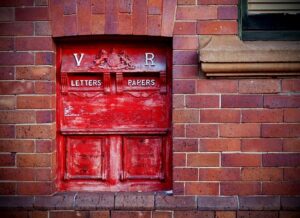 Red post box set into brick wall