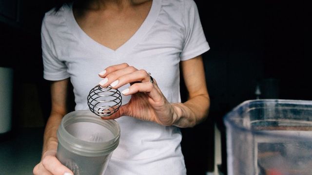 Trade Secrets Woman Holding Protein Shake Mixer