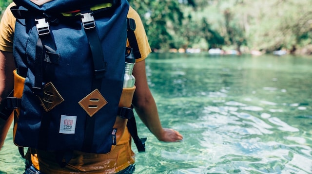 Travel Blog Backpacker Wading in Stream