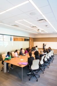 Woman standing at a whiteboard in front of teammates