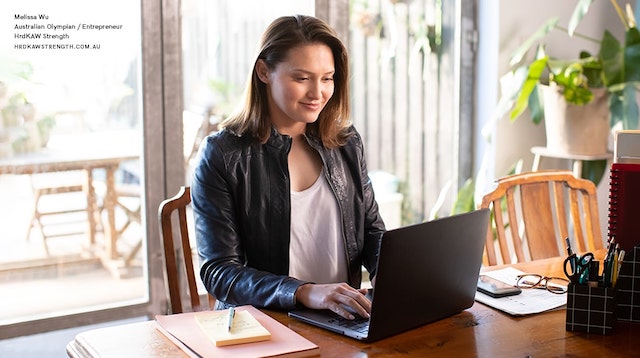 Melissa Wu at a desk with a laptop