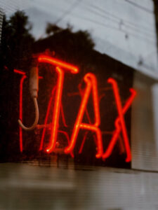 Neon red sign that reads “Tax”