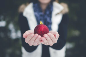 Person holding red holiday ornament