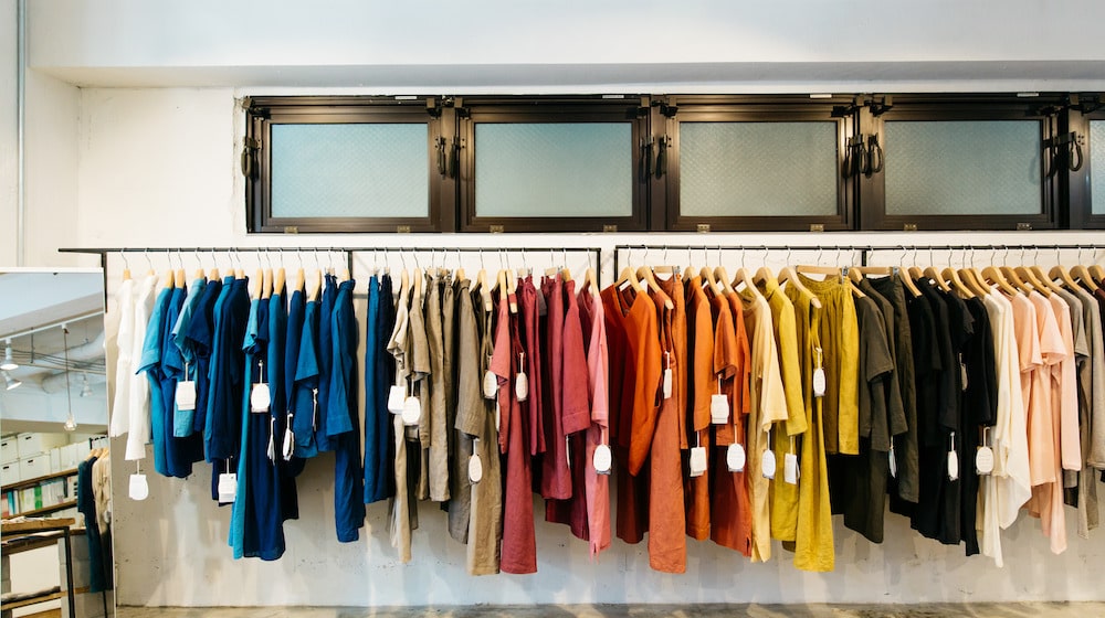 Bright coloured shirts with pricetags on a rack