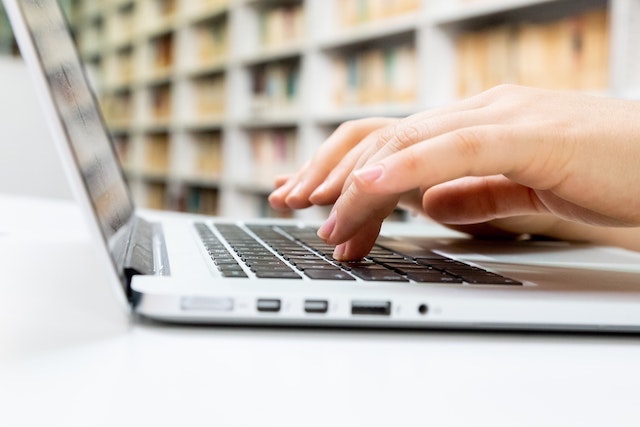 Close-up of person typing on laptop