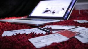 Open laptop and bank cards on a red rug