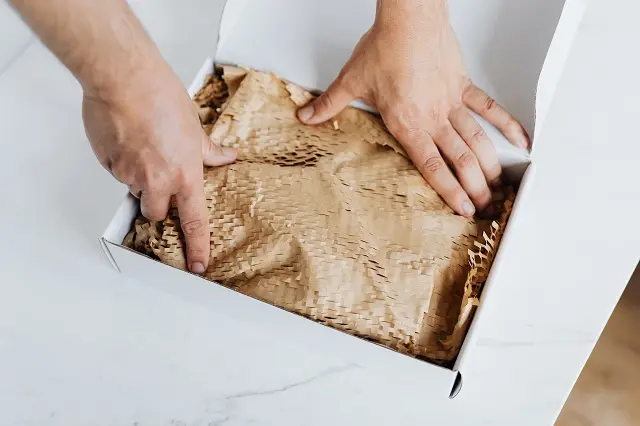 Person packing a product into a box