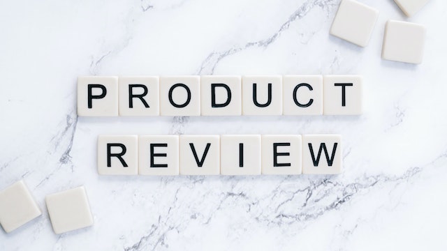 Lettered tiles spelling “product review” on marble surface