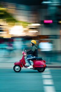 Man driving a red scooter