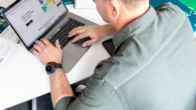 Man looking at GoDaddy website on a laptop