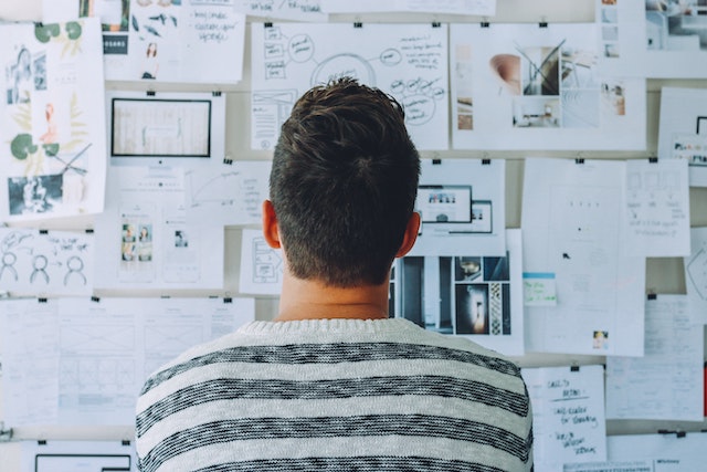 Man looking intently at papers on a white board