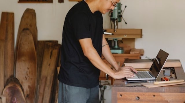 Man working on laptop in a workshop