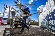 Men loading glass windows onto a ute