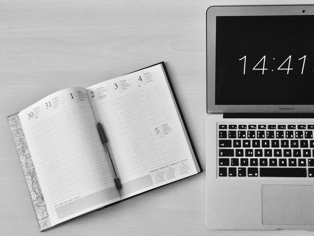 Open calendar notebook next to laptop.