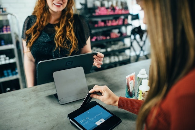 Retail worker smiling as customer slides card