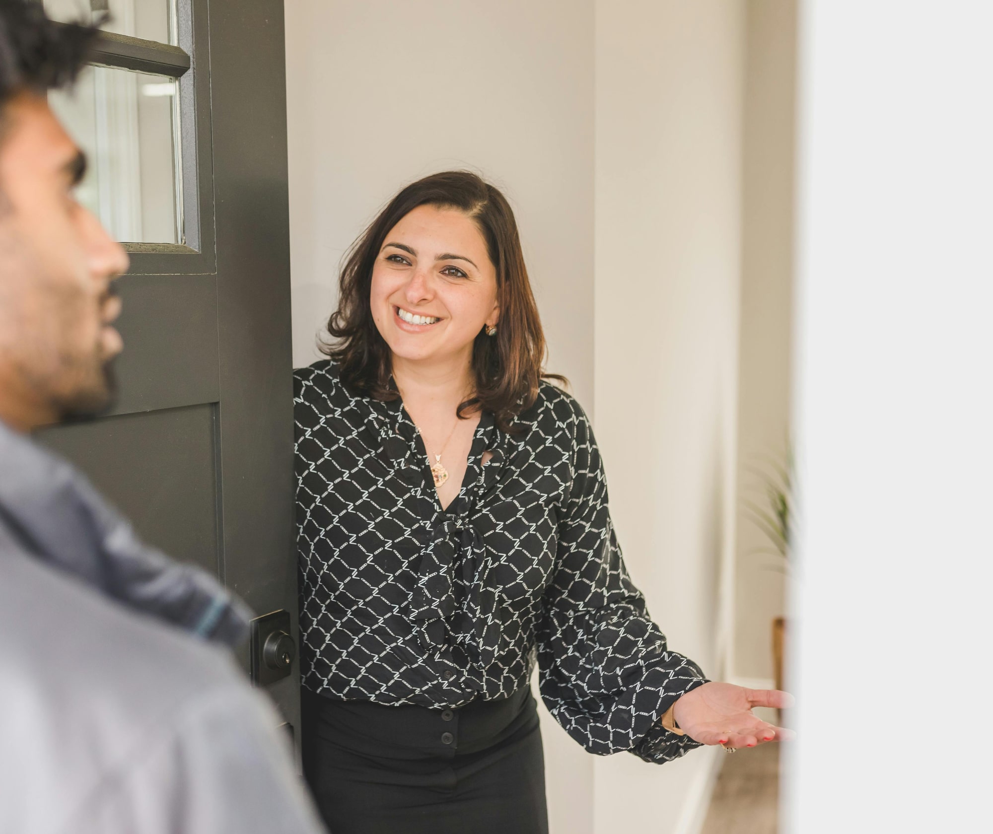 Female estate agent welcoming a buyer into a home for sale