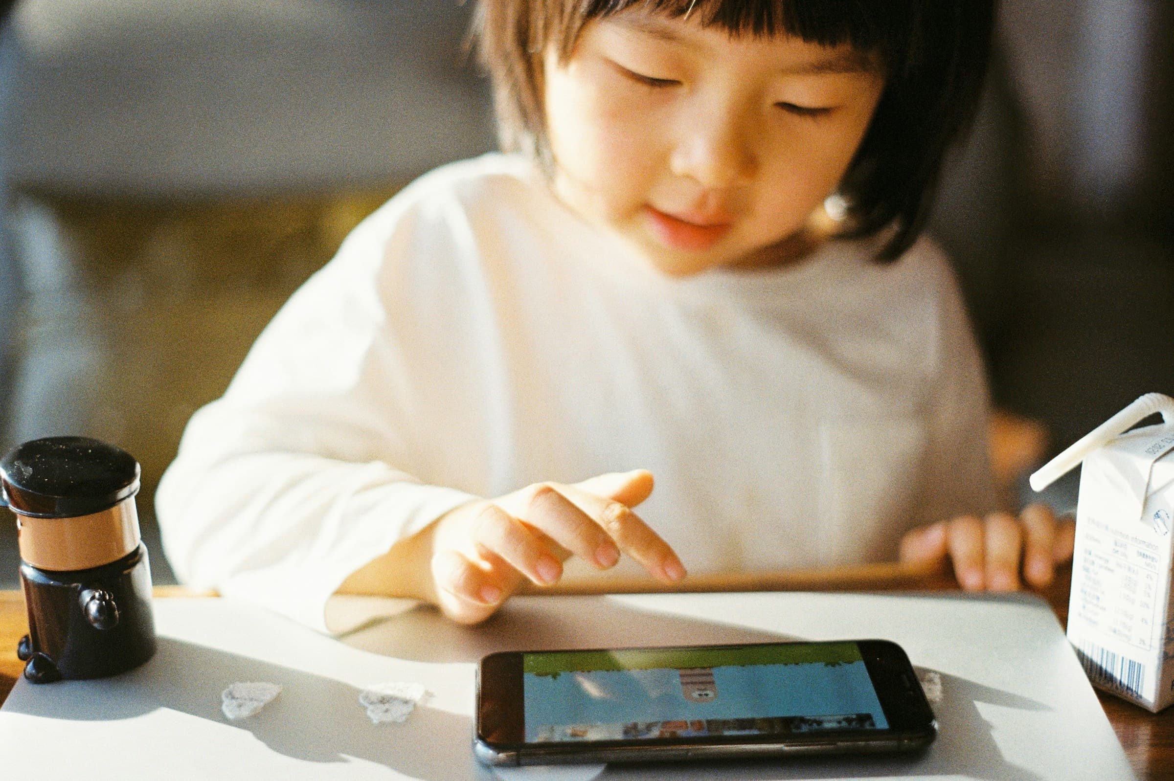 Little girl playing a game on a phone