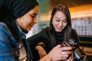 Two women looking at photos on a camera