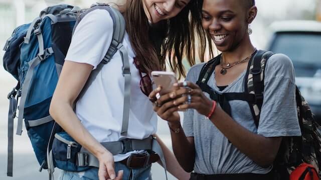 Two young women looking at something on a cellphone