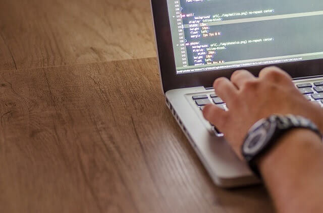 Person working at laptop with code in view