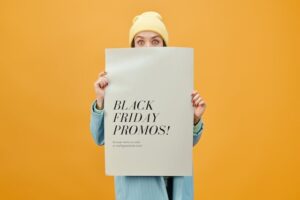 Woman holding a sign that says Black Friday promos