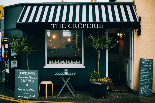 Creperie storefront with small table outside