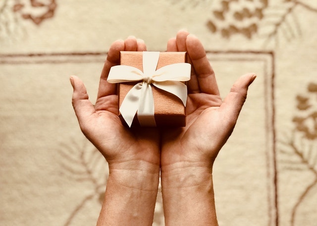 Man Holding Out a Wrapped Gift