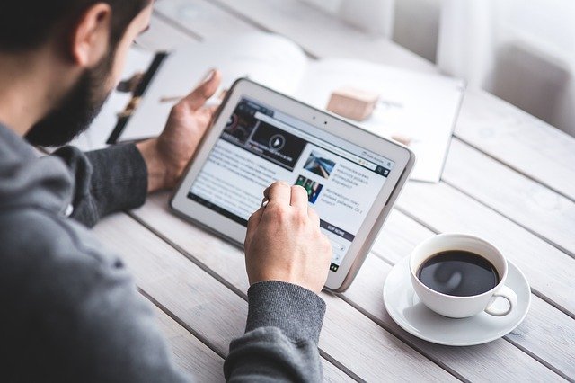 Man reading something on a touchscreen tablet