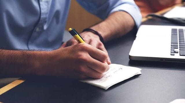 Market Research Man Jotting Notes on Paper